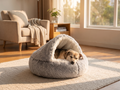 Dog nestled inside the hooded PawSerene Calming Nest cave bed in a cozy living room